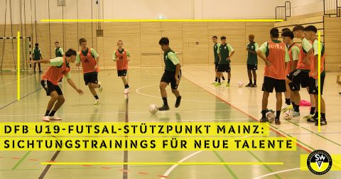 Zwei Futsal-Spieler im Zweikampf. Daneben stehen einige Spieler und schauen sich die Situation an. 