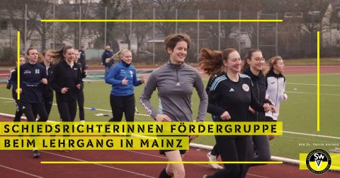 Schiedsrichterinnen auf einer Laufbahn um ein Spielfeld beim Konditionstest. 